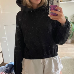 Svart hoodie med huva - Enkel svart hoodie med huva och långa ärmar. Tröjan har en loose passform och är perfekt för chill dagar. Mjuk och skön, med resår i ärmslut och nederkant. Passar till allt och är ett måste i garderoben.