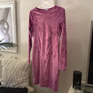 Rosa sammetsklänning från NLY Trend - Säljer en rosa sammetsklänning från NLY Trend i storlek L. Klänningen är kort, har lång ärm och en tight passform. Materialet är mjukt och glansigt, vilket ger en lyxig känsla. Perfekt för dig som vill sticka ut med en cool och trendig look.