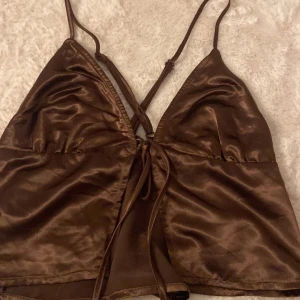 Brun satinlinnetopp från H&M - Snygg brun linnetopp i satin från H&M i storlek M