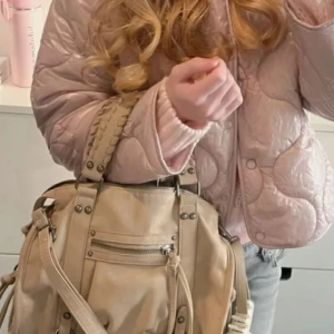 Bershka city bag - Öppen för byte mot den i svart.💗💗Säljer en beige axelväska med snygga flätade handtag och coola nitar. Aldrig andvänd så jag nyss beställde den men ångrar mig, köpt för 450kr💗