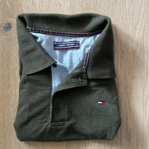 Olivgrön pikétröja Tommy Hilfiger  - Grön Tommy hilfiger pike säljes billigt, Strlk M mått är bara att fråga om, skriv vid minsta fundering osv🤗