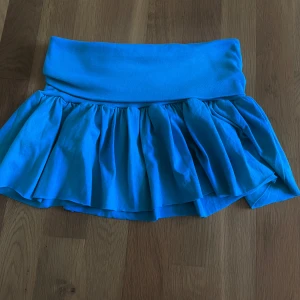 Blå volangkjol  - Supersöt blå kortkjol med bred midjeresår och volangkant, som man kan vika ned. Den är stretchiga och har en luftig känsla, perfekt för varma dagar. Man kan även använda den som topp om man vill. Skriv om frågor! :)