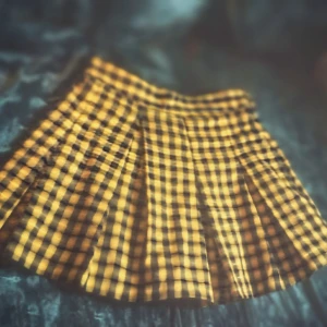 Gul och svart rutig plisserad kjol - Superfin kort plisserad kjol i gult och svart rutigt mönster. Kjolen har klassisk skoluniform-vibe och är perfekt för dig som vill sticka ut. Materialet känns lätt och passar bra till sneakers eller boots.