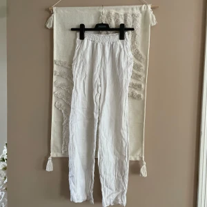 Vita linnebyxor från Chelsea Girls XXS - Säljer ett par vita linnebyxor från Chelsea Girls i storlek XXS. Byxorna har resår i midjan för en skön passform och är tillverkade i ett lätt och luftigt linnematerial. Perfekta för varma dagar och en chill stil.