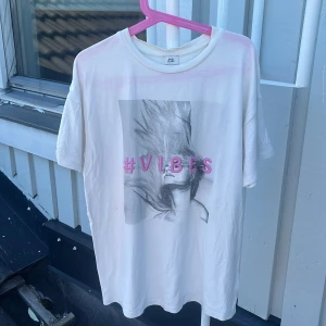Vit t-shirt #VIBES River Island - Vit t-shirt från River Island med tryck av en svartvit bild och texten #VIBES i rosa framtill. Klassisk rund hals och korta ärmar. Perfekt för dig som gillar coola statement-plagg med en chill vibe.