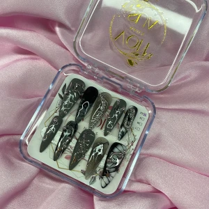 ObsidianLace (XS);Long Stiletto  - Snygga press-on naglar i svart och grått med coola silvriga 3D-detaljer och charms i silver . Långa, spetsiga och med unika mönster och effekter. Perfekt för dig som vill sticka ut med riktigt edgy naglar. Kommer i storlek XS: 14 mm, 11 mm, 11,5 mm, 10 mm, 8 mm 