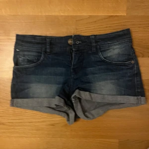 Mörkblå lågmidjade jeansshorts  - Snygga mörkblå jeansshorts från Sinsay i storlek XS. Perfekta för varma dagar och enkla att matcha med allt. Jeansmaterialet är mjukt och bekvämt.