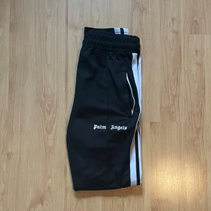 Palm Angels byxor - Tja! Säljer dessa Palm angels byxor i ett fint skick utan defekter! Byxorna är i storlek L men är något tightare så passar mig som brukar bära M. Ej säker på om de är äkta. Hör gärna av dig vid frågor eller prisförslag!