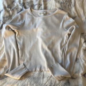 Ljusbeige tunn ribbad tröja Pull&Bear - Säljer en ljusbeige tunn långärmad tröja från Pull&Bear i storlek S. Tröjan är ribbad och har en rund halsringning, perfekt för dig som gillar enkla och stilrena plagg. Materialet är mjukt och stretchigt, vilket gör den skön att bära hela dagen.