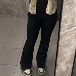 Svarta kostymbyxor - Säljer mina svarta kostymbyxor som har slits på sidorna längst ned, säljer dessa då de inte längre passa mig! De är i bra skick och har inga defekter. 