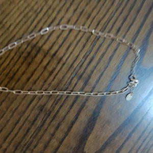 Guldigt halsband med rektangulära länkar - Snyggt halsband i guldton med rektangulära länkar och en liten rund bricka vid låset. Perfekt för dig som gillar minimalistisk och trendig stil. Länkarna ger ett coolt och modernt uttryck som passar till många outfits.