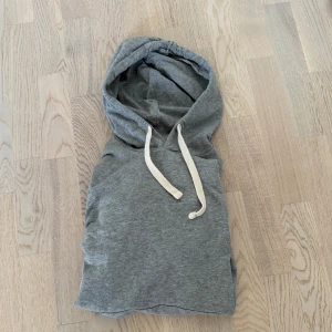 Grå hoodie med snörning från Jack & Jones - Säljer en enkel grå hoodie med vit snörning i huvan och stor magficka framtill. Tröjan har långa ärmar och ribbade muddar vid ärmslut och nederkant. Perfekt för chill dagar eller när du vill vara extra bekväm. Nypris 600kr, knappt använd!
