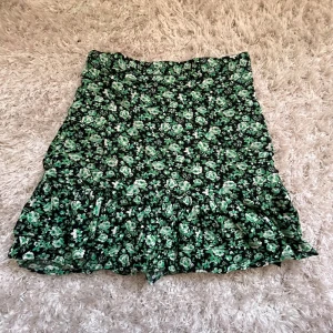 Grön blommig volangkjol - Kort blommig kjol med ”töjbar” midja. Passar xs/s!