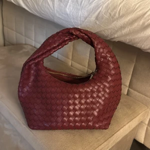 Vinröd trendig väska från Ginatricot - Säljer denna snygga väska från ginatricot. Den är helt i nyskick då den endast använts 3 gånger. Säljer pga jag har många andra väskor jag använder mer. 💕