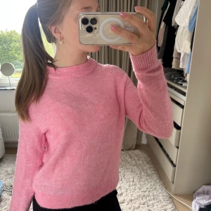 Rosa stickad tröja från Vero Moda - Supermjuk rosa stickad tröja från Vero Moda med rund halsringning och ribbade muddar. Perfekt för lager-på-lager och ger en söt vibe till din outfit. Långärmad och i en skön loose passform som är både chill och snygg.