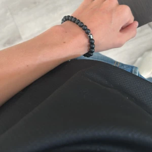 Set med tre pärlarmband i olika färger - Säljer ett set med tre stilrena pärlarmband. Ett svart matt armband med silverdetalj, ett vitt armband med grå marmorering och ett blått armband med glansiga pärlor. Perfekta accessoarer för att lyfta din outfit och ge en cool vibe. Säg till om det behövs fler bilder så löser jag de!