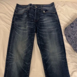 Blå jeans från G-Star RAW - Snygga blå jeans från G-Star RAW med klassisk femficksdesign och coola slitningar framtill och baktill.