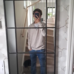 Beige half zip tröja från RYVLS - Snygg beige långärmad tröja från RYVLS med half zip och ribbad krage. Mjuk och skön känsla, perfekt för chill dagar. Passar dig som gillar enkel stil med lite edge. Materialet är stickat och färgen är neutral beige.