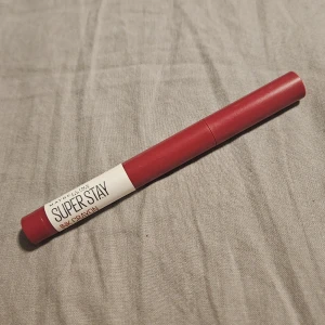 Maybelline Super Stay Ink Crayon - Maybelline Super Stay Ink Crayon i en snygg mörkröd nyans. Läppennan har en smal och smidig form som gör det enkelt att applicera färgen exakt. Perfekt för dig som vill ha intensiva och hållbara läppar med matt finish. Pennan är tillverkad av plast och har en praktisk twist-up funktion.