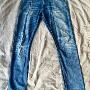 Tiger of Sweden jeans  - Tiger of Sweden jeans, modell Pistolero, storlek 30/32. Hål på höger knä, annars i fint skick utan andra skador. Snygga och bekväma, perfekta för casual stil.