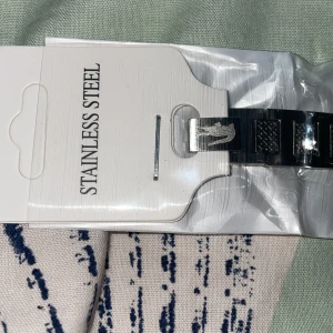 Silverfärgat armband i rostfritt stål - Snyggt armband i silverfärgat rostfritt stål med coola detaljer och mönstrade länkar. Armbandet har en stilren design och passar perfekt för dig som gillar en modern och clean look. Liten Nike-logga på spännet för extra streetkänsla.