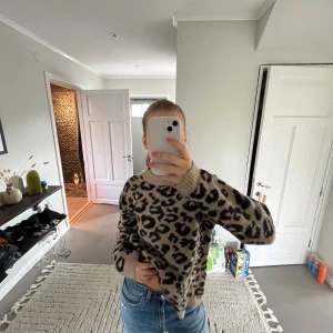 Beige leopardmönstrad stickad tröja - Säljer en beige stickad tröja med svart leopardmönster. Perfekt för dig som vill ha en cool och trendig look. Passar till jeans eller kjol🩷
