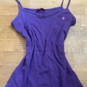 Lila linnetopp från edc, storlek M - Säljer en vintage lila linnetopp från edc med smala axelband och en liten broderad logga framtill. Toppen är i mjuk bomull och har en enkel passform som är perfekt till jeans eller kjol. Superskön och stilren för dig som gillar färg!