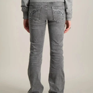 Grå bootcut jeans med broderi - Snygga grå jeans med bootcut passform och broderade detaljer på bakfickorna. 😍