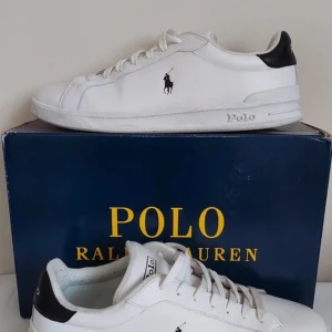 Vita Ralph Lauren Sneakers - Vita Ralph Lauren sneakers i storlek 44 säljes! Skorna har en klassisk och stilren look med den ikoniska polo loggan på utsidan av skon 👟 | Skick: 10 / 10, knappt använda | Nypris: ca 1600 | Vårt pris: 899 | Storlek: 44 | OBS boxen medföljer inte!