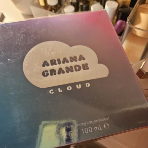Ariana Grande Cloud Parfym 100ml - Ariana Grande Cloud är en parfym i en snygg box med blå-lila gradient och vit molnlogga. Flaskan innehåller 100 ml eau de parfum spray. Doften är känd för sina söta och fräscha toner, perfekt för dig som gillar trendiga och populära kändisdofter.