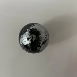 Jordglob  - utan en liten svart och silverfärgad jordglob med tydliga lands- och havsnamn. Perfekt för dig som gillar geografi, resor eller vill ha en snygg detalj på skrivbordet. Inspirerar till att utforska världen och lära sig mer om olika länder och platser. Den är också magnetisk