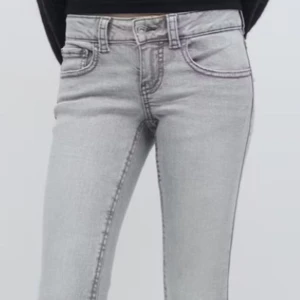 Grå jeansbyxor med raka ben - Snygga grå jeansbyxor med raka ben och klassisk femficksdesign. Byxorna har stora bakfickor med lock och knapp, samt normal passform och hög midja. Perfekta till vardags för en stilren look.