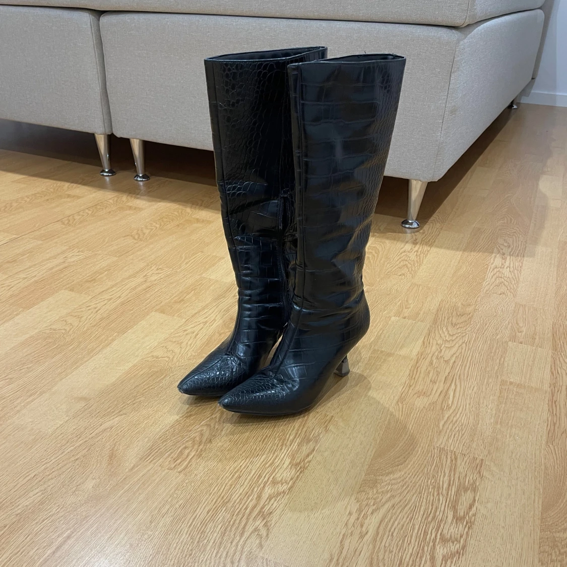 Svarta höga stövlar med krokodilpräglat mönster