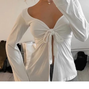 Vit långärmad omlottopp med knyt - Från design by si!! Storlek xs/s , använd fåtal gånger