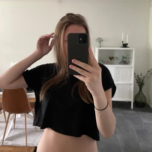 Kroppad svart t-shirt - Kroppad svart t-shirt i väldigt bra skick. Liten ficka på bröstet och ärmarna är uppvikta en liten bit. 💕