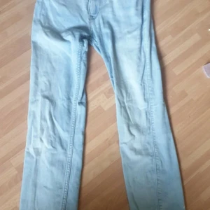 Ljusblå Lee jeans straight fit - Säljer ett par ljusblå jeans från Lee med klassisk femficksdesign och raka ben. Jeansen har snygga kontrastsömmar och Lee-läderpatch bak i midjan. Perfekta för dig som gillar en clean och enkel look.