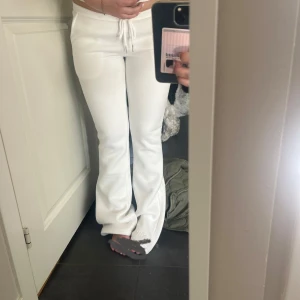 Vita bootcut och lågmidjade  mjukisbyxor  - Säljer ett par vita mjukisbyxor med bootcut passform och snörning i midjan. Byxorna har normal passning och är HELT nya. Dom är lågmidjade!! Köpte för 500