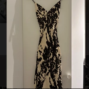 NAKD långklänning med öppen rygg - Snygg långklänning med leopardmönster, smala axelband och v-ringning. Klänningen har en öppen rygg med korsade band och är figurnära. Perfekt för dig som vill sticka ut med ett djurmönster. Klänningen har dragna trådar på vissa ställen, men det är inte jätte noterbart (se bild 3 & 4).