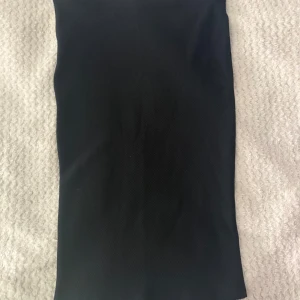 Svart tight kjol från Street One - En svart, enkel och tight kjol från Street One. Kjolen är kort och har en stilren, rak passform utan synliga detaljer eller mönster. Materialet känns mjukt och stretchigt, perfekt för en clean och minimalistisk look.