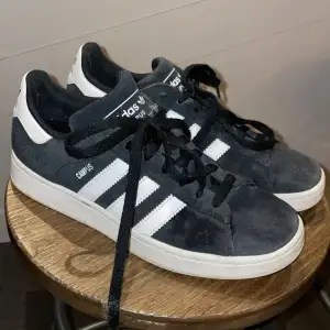Snygga svarta Adidas Campus 2 sneakers med klassiska vita ränder och svart snörning. Använda men fortfarande in bra skick. 