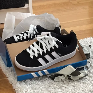 Svarta adidas campus - Säljer dessa adidas campus i nyskick, som är i storlek 38❤️de är knappt användna eftersom de inte är min stil💞men de har inga defekter och har med två snören, svart och vit.