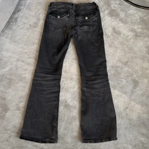 Svarta bootcut jeans - Snygga gråa bootcut jeans från Gina Tricot med klassisk femficksdesign och knappgylf. Fickor bak med metallknapp. Bra skick! 