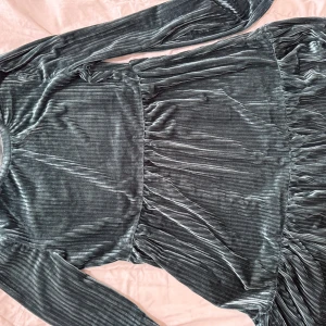 Mörkgrön sammetklänning - Snygg mörkgrön klänning i sammet med långa ärmar och ribbad textur. Perfekt för en elegant look.