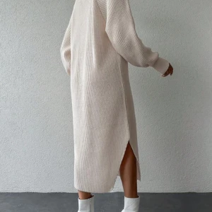 Beige stickad långklänning - Snygg beige stickad långklänning med slits på sidan. Mysig och bekväm passform. Långärmad design som ger en avslappnad look. Använd 1-2 gånger. Onesize