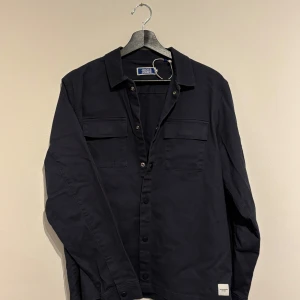 Jack and jones Overshirt  - Säljer denna riktigt snygga overshirten från Jack and Jones. Den är i nyskick och är i storlek 176. Men den sitter större som än S-M. Vid fler frågor hör gärna av dig. Vid snabb affär kan priset diskuteras. 