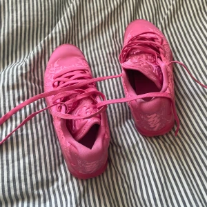 Zion 3 basket skor - Säljer ett par rosa Nike Air Jordans med snörning och unikt mönster. Skorna har en rund tå och är perfekta för dig som älskar färgglada sneakers. De är både snygga och bekväma för vardagsbruk.