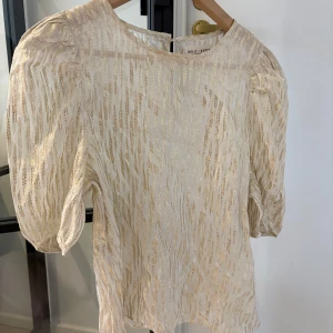 Glittrig tröja - Festlig tröja med guldigt glitter. Den är nästan aldrig använd alltså är den i fint sick. Storleken är M men jag som har xs passar i den.