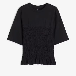 Svart topp med rynkad detalj - Snygg svart topp med rynkad detalj på framsidan och volang vid nederkanten. Toppen har trekvartsärm och en rund halsringning. Perfekt för en stilren look.