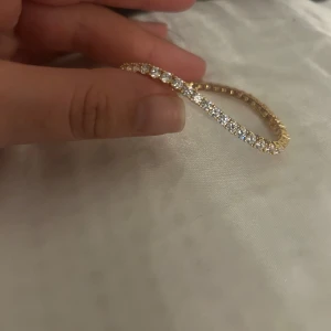 Guldarmband med glittriga stenar - Ett heeelt nytt tennisarband som råkade vara för litet. 18k guldpläterat, perfekt för att addera lite glamour i outfiten. 6 tum lång 