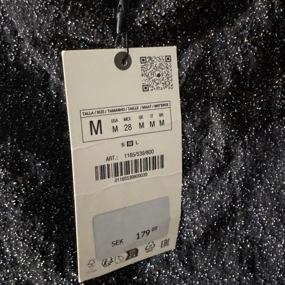 Säljer en svart glittrig topp med korta ärmar. Perfekt för att lysa upp vilken outfit som helst. Toppen har en elegant och festlig känsla, idealisk för speciella tillfällen.. Puserot.